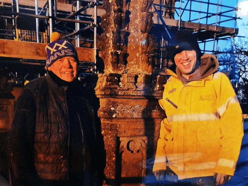 Two stonemasons repairing the church tower