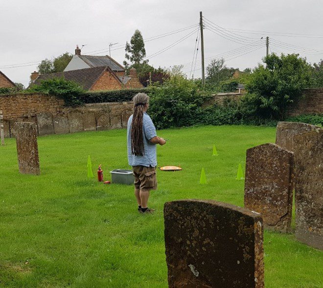 Person piloting a drone in a churchyard