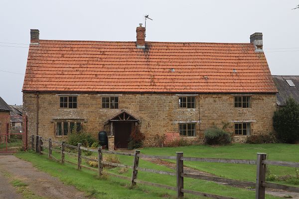 Large farmhouse with fenced front lawn
