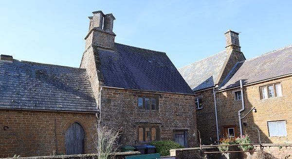 Cottage and outbuildings located at right-angles to another building