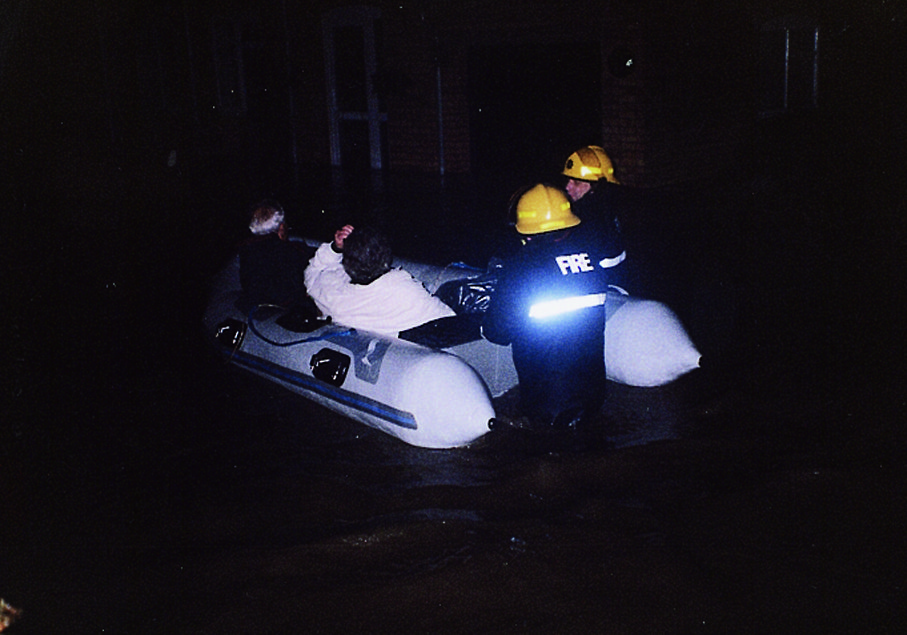 People being rescued from floods in an inflatable boat