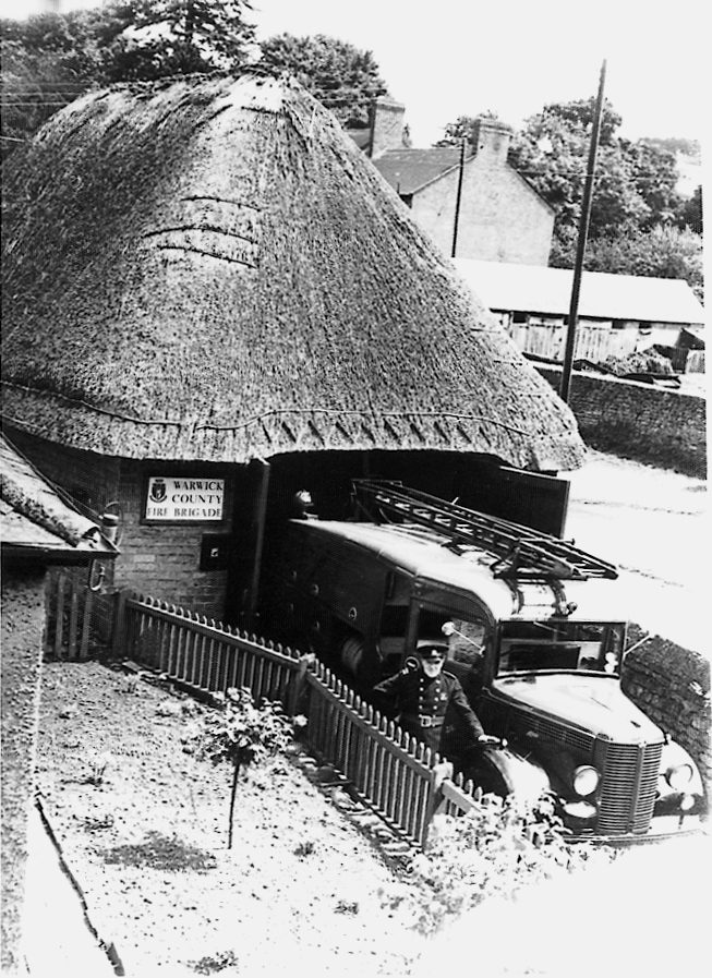 Fire engine parked outside thatched fire station