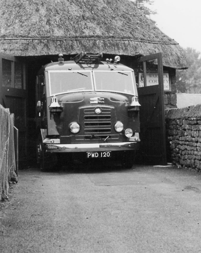 Fire engine at entrance of thatched fire station