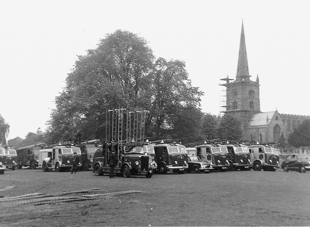Display of fire engines, with a church in the background