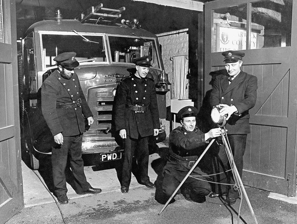 Group of firemen at entrance to fire station