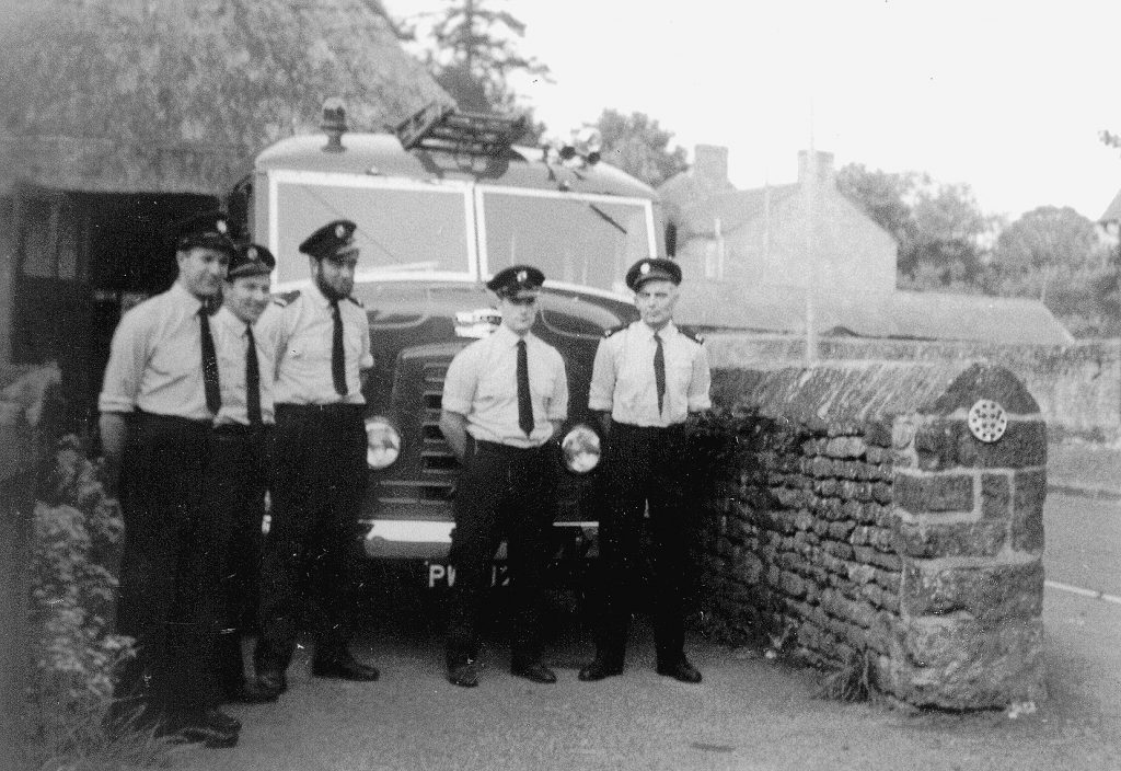 Group of firemen at entrance to fire station