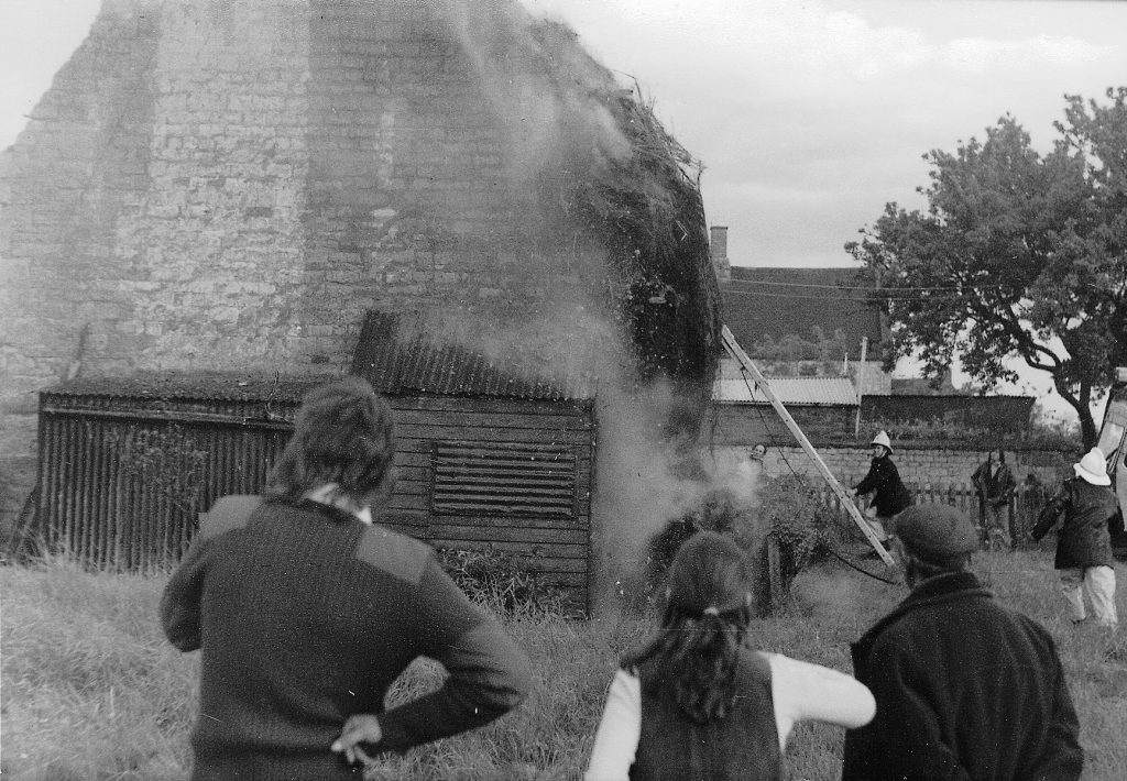 Fire brigade tackling thatched roof fire