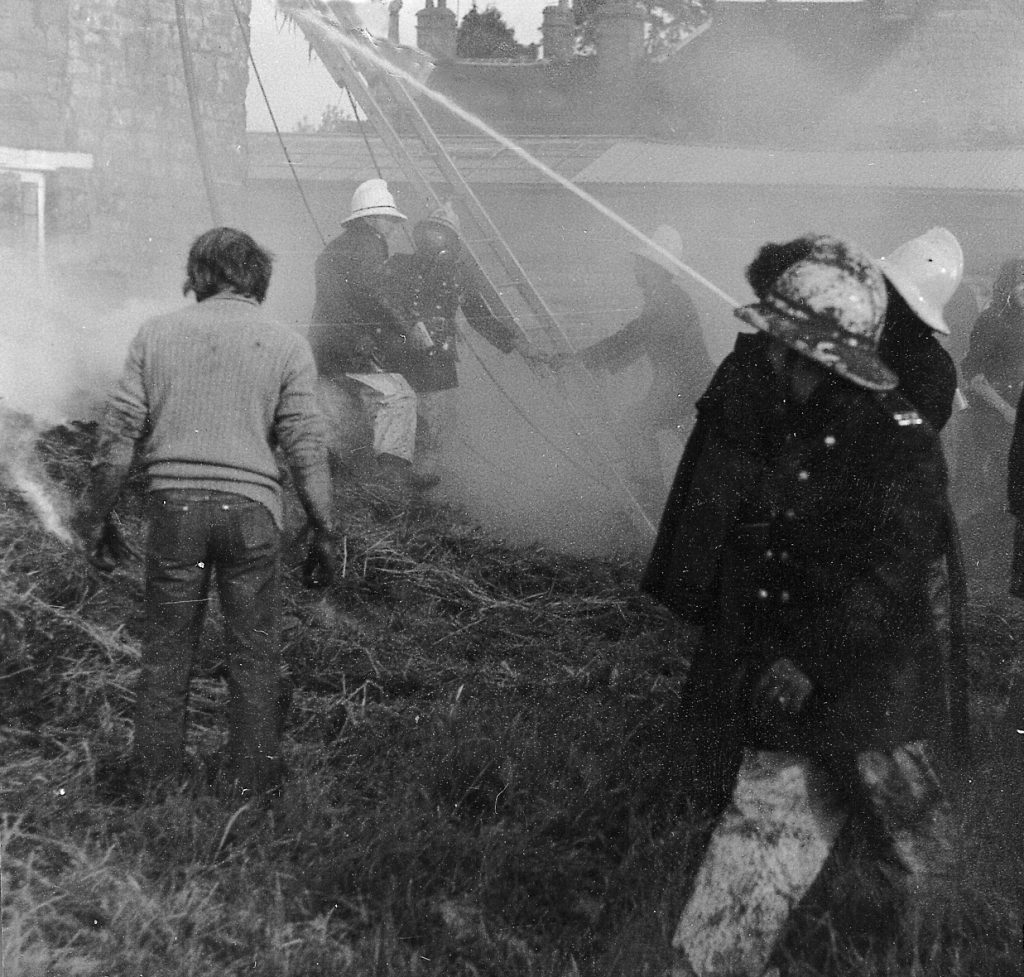 Fire brigade tackling thatched roof fire