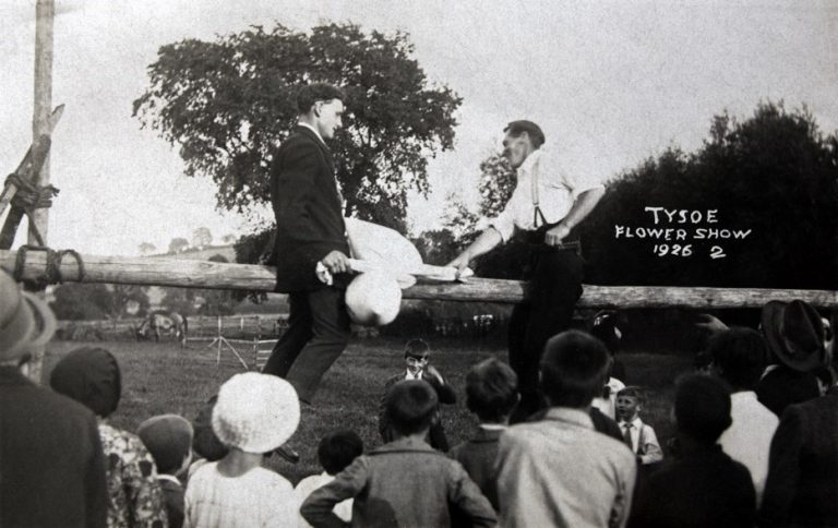 Two men taking part in a 'slippery beam' game 