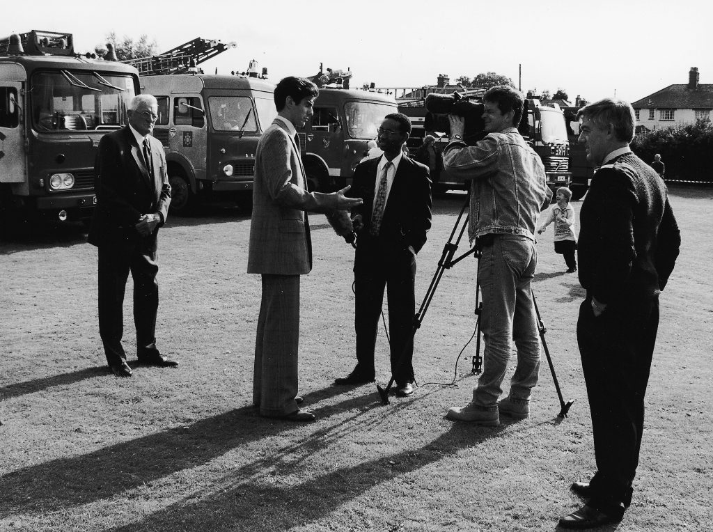 TV crew in front of a display of fire engines